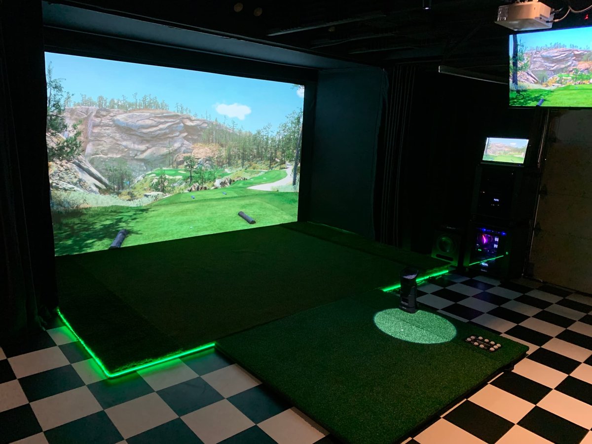 Golf simulator enclosure with steel frame and turf