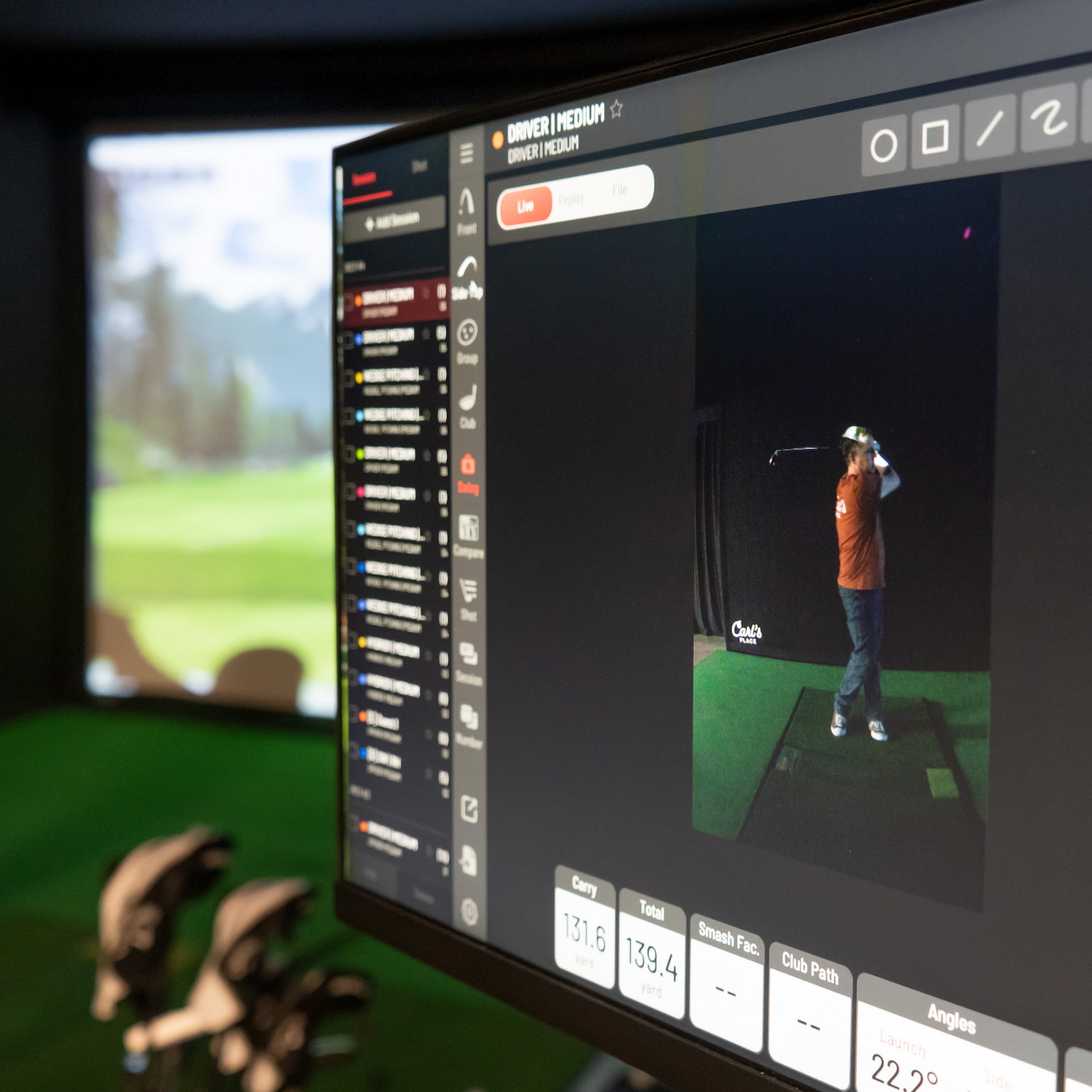 Launch monitor on the hitting mat of a golf simulator bay